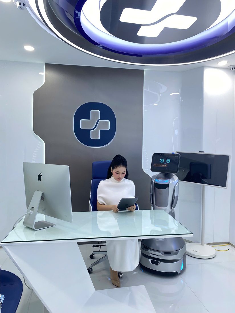 Robot GreetingBot Nova làm trợ lý lễ tân bên cạnh quầy tiếp đón của một phòng khám
